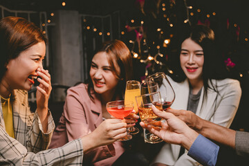 A group of cheerful friends enjoy drinks at a joyful celebration. They smile and laugh, sharing moments of happiness, togetherness and relaxation in a lively social atmosphere.