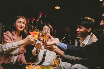 A group of cheerful friends enjoy drinks at a joyful celebration. They smile and laugh, sharing moments of happiness, togetherness and relaxation in a lively social atmosphere.