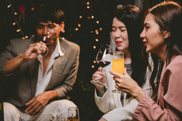 A group of cheerful friends enjoy drinks at a joyful celebration. They smile and laugh, sharing moments of happiness, togetherness and relaxation in a lively social atmosphere.