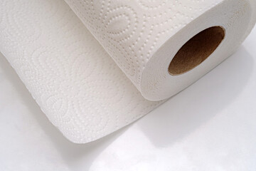 A close-up view of a roll of kitchen disposable towel. Towel roll textured surface and cardboard core. Selective focus.
