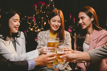 A group of cheerful friends celebrating, holding glasses of beer and laughing together. A lively gathering shows bonding, happiness and relaxation in a lively atmosphere.
