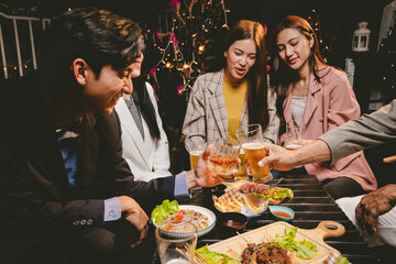 A group of cheerful friends celebrating, holding glasses of beer and laughing together. A lively gathering shows bonding, happiness and relaxation in a lively atmosphere.