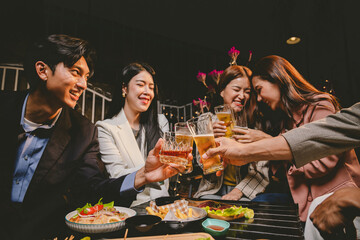 A group of cheerful friends celebrating, holding glasses of beer and laughing together. A lively gathering shows bonding, happiness and relaxation in a lively atmosphere.