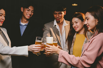 A group of cheerful friends celebrating, holding glasses of beer and laughing together. A lively gathering shows bonding, happiness and relaxation in a lively atmosphere.