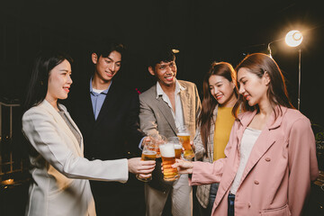A group of cheerful friends celebrating, holding glasses of beer and laughing together. A lively gathering shows bonding, happiness and relaxation in a lively atmosphere.