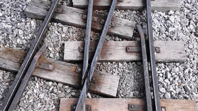 Train Tracks Switch: A close-up shot of weathered, worn railway tracks branching out in an intricate switch.  A textured abstract shot of a train switch, showing the details of the old railroad.