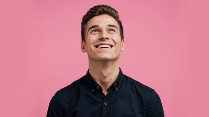 Obraz premium Man with Joyful Expression Looking Upwards in Black Shirt, Against a Solid Pink Background, Conveying Satisfaction and Happiness, Capturing Positive Emotions in a Minimalist Setting