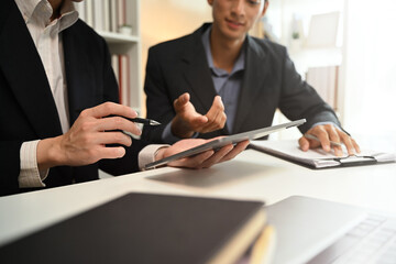 Cropped shot business advisor explaining the contract offering it for the client to sign.