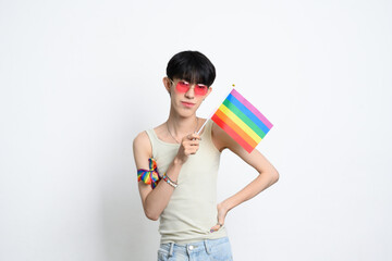 Portrait of young man in pink sunglasses holding a rainbow pride flag. Human rights and LGBTQ community concept