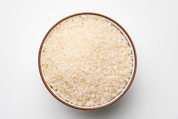 A bowl of raw white rice with a shadow, isolated on white background