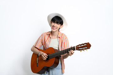 Pretty asian man wearing a straw hat holding a guitar against white background
