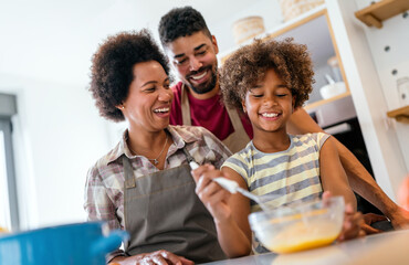 Overjoyed young african american family with kid have fun cooking at home together,