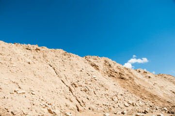 mountain of sand against blue sky