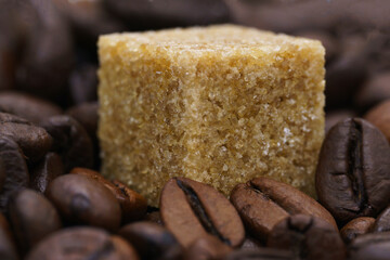 beautiful picture, a background with coffee and sugar, a cube of cane sugar on coffee beans, a close-up of a coffee and sugar