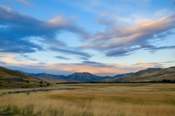 Obraz premium A serene scene featuring a green field with mountains in the distance, perfect for backgrounds or outdoor-themed projects