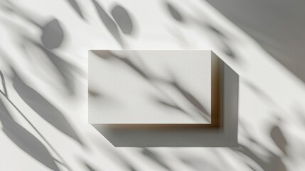 A minimalist white block casting shadows on a surface, evoking a serene atmosphere.