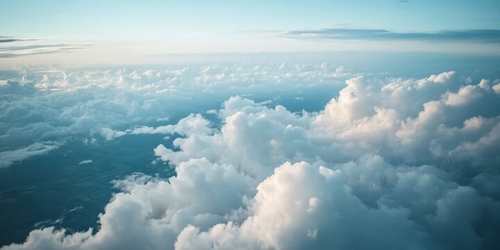 Aerial view of land and clouds captured from an airplane, showcasing the stunning interplay of terrain and cloud formations visible during the flight from the airplane perspective.
