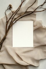 Mockup of a white greeting card on an aesthetic fabric background and dry branches. Perfect for stationery and minimalistic design projects.