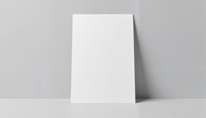 Vertical blank paper against light grey wall.