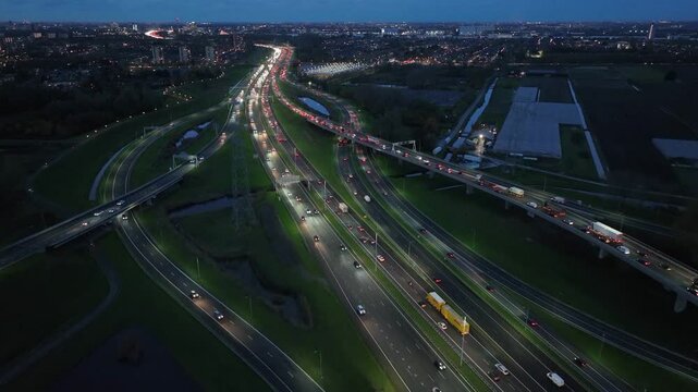 Rotterdam, Netherlands - Night aerial drone view of a multi-level highway junction with moving cars in the city. A DHL truck drives on a multi-level road junction. The concept of urban.