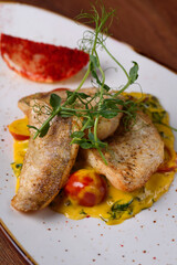 trout in sauce with macro microgreens.
