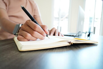 Selective Focus on Woman’s Hand Writing in a Journal