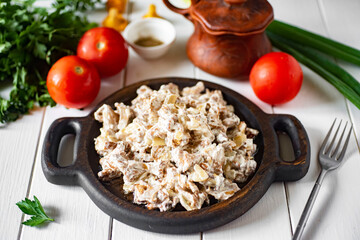 Wild mushrooms in sour cream on a wooden plate on a white background. Fried chanterelles with sour cream for lunch. Close-up