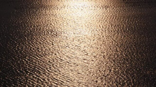 Sun glitter visible over the calm sea. At sunset