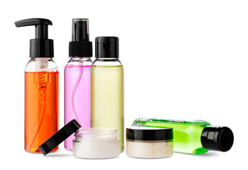 Variety of colorful personal care bottles and grooming accessories arranged on a white surface