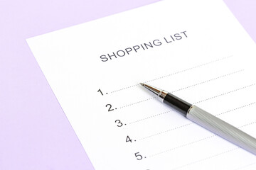 Silver pen lies on Checklist form, Shopping list of purple color.