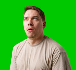 Man making a humorous expression against a bright green background