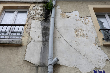 Décollement d'enduit de façade en raison d'un fuite d'eau de gouttière