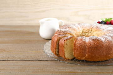 Freshly baked sponge cake, milk and berries on wooden table, closeup. Space for text