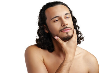 Young man with curly hair thoughtfully posing against a plain background