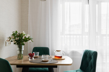 A Modern Dining Space Featuring Refreshing Tea and Beautifully Arranged Fresh Flowers