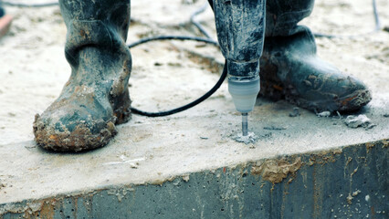 Close-up of drilling into concrete at a construction site. A detailed close-up of a construction...