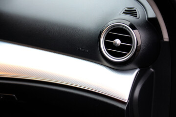 Car air vents close-up grille. Air ventilation grille with power regulator. Modern Car air conditioner, interior of a new modern car. Passenger airbag. Front airbag.