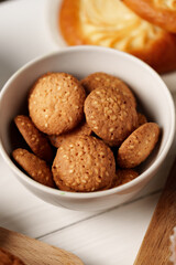 Freshly baked sesame cookies in a white bowl ready for a delightful snack or dessert experience