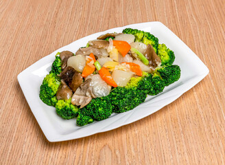 Stir fried Scallops with Greens including broccoli, tomato and scallions served in tray dish isolated on wooden table side view of hong kong food