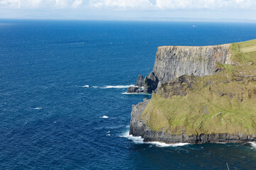 Dramatic coastal cliffs of the Cliffs of Moher, Ireland, meet the churning blue Atlantic Ocean. ...