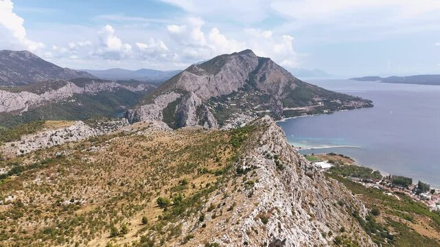 Flying over the mountain ridge towards Omis town in Croatia during summertime