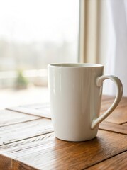White ceramic mug on wooden table near window with natural light streaming in during morning hours