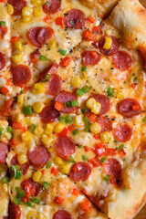 pizza with sliced sausages and corn