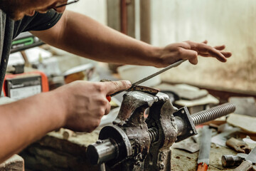 Manual sanding of metal part in vice