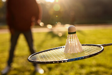 Badminton racket and shuttlecock in park on sunny day, selective focus
