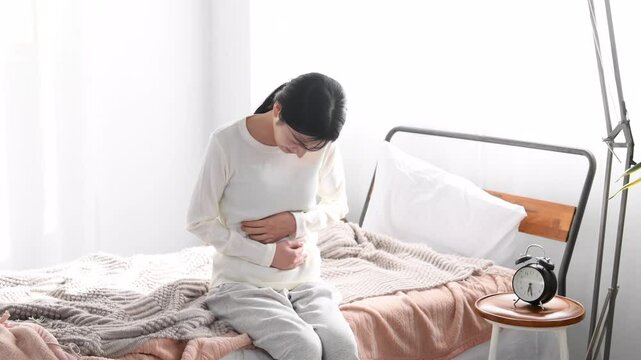お腹の痛みを訴えるアジア人の若い女性