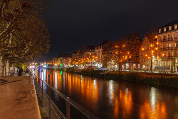Obraz premium Illuminated riverside promenade in Strasbourg at night.