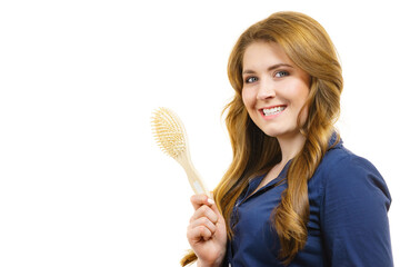 Woman brushing long healthy brown hair