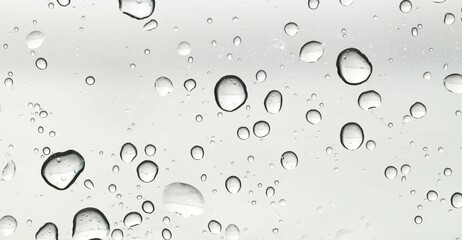 Water drops on light grey glass surface, top view