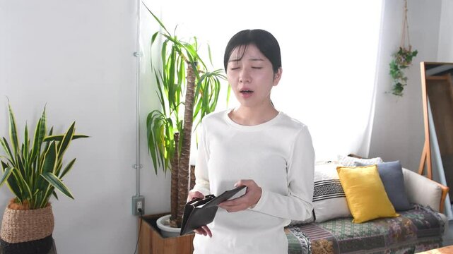 財布を持ち困る私服姿の若いアジア人女性